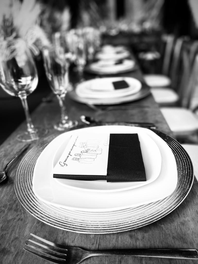 Lugar de mesa con servilleta negra y tarjeta de agradecimiento