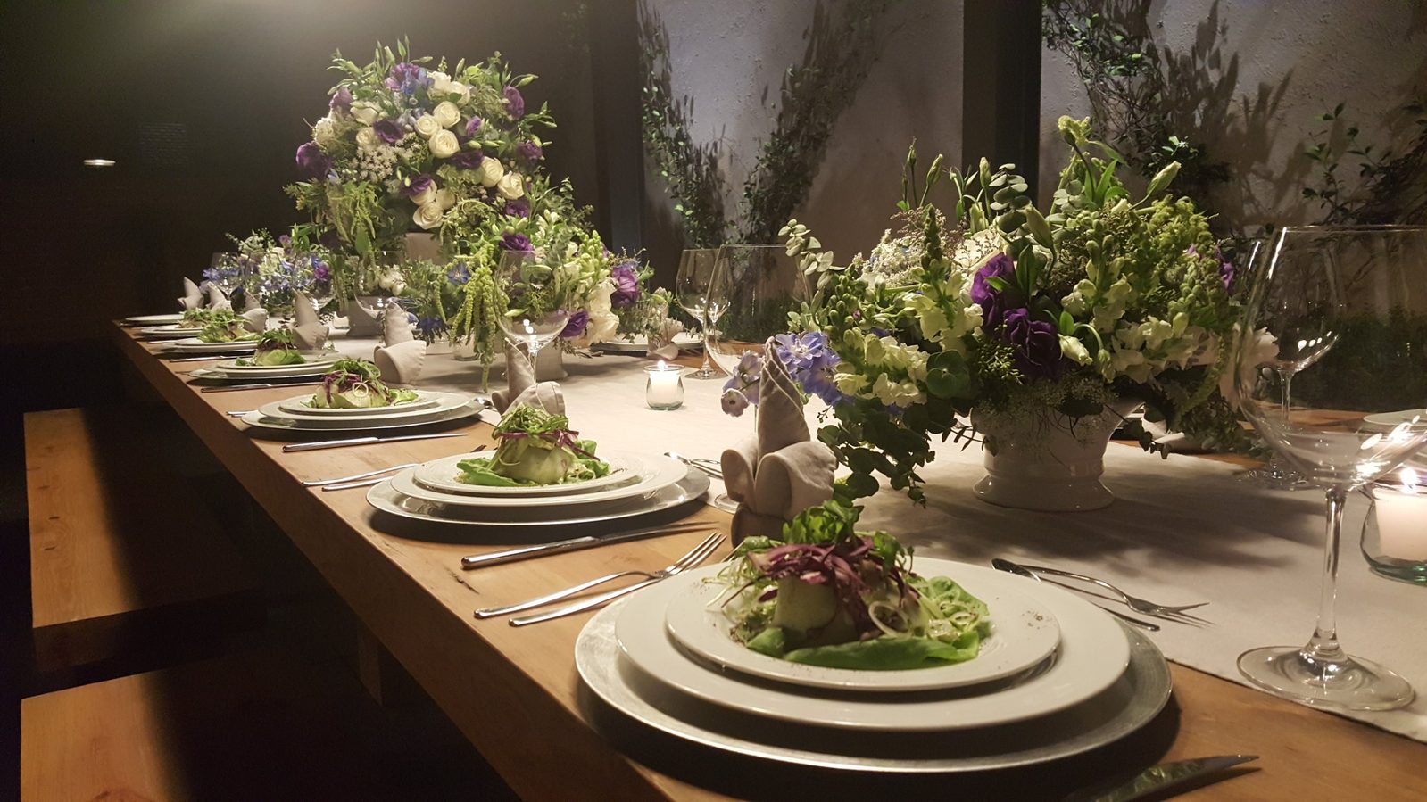 Mesa de boda con arreglos florales y entradas emplatadas