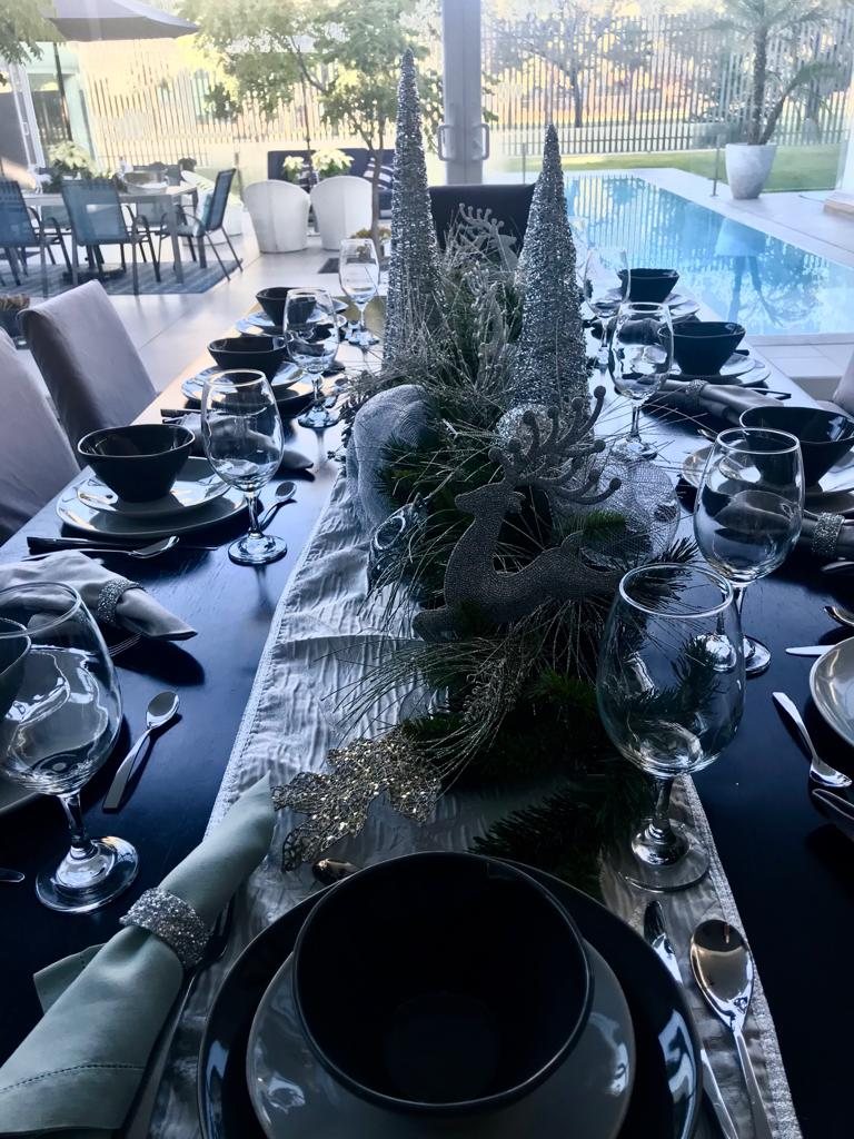 Mesa navideña junto a la alberca con centro de mesa plateado