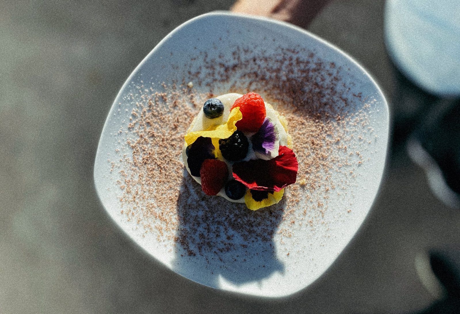 Postre con frutos rojos y flores comestibles