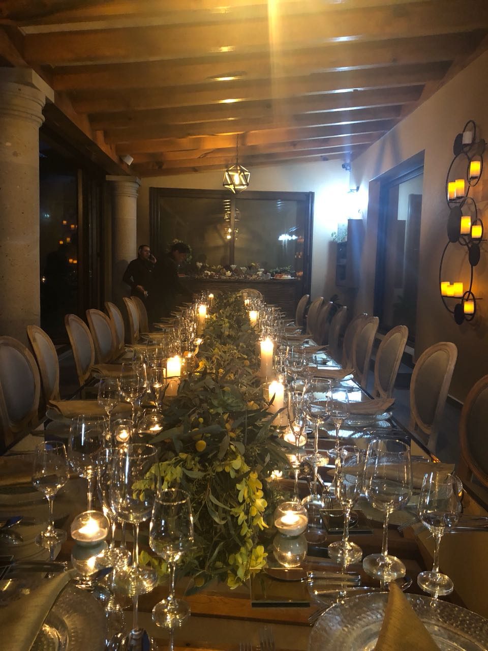 Mesa de cena con velas y flores amarillas