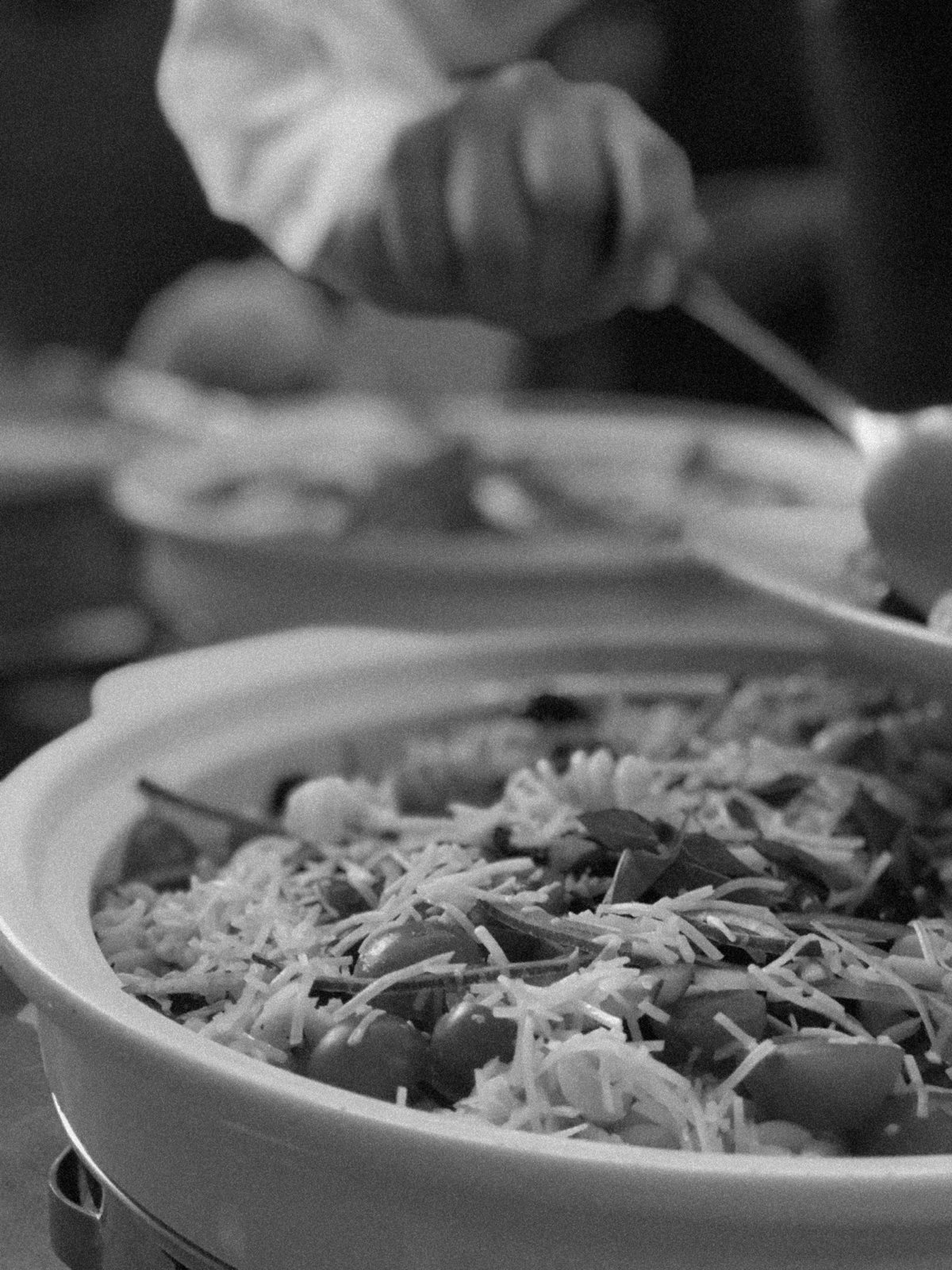 Pasta servida en chafer durante un llamado, en blanco y negro