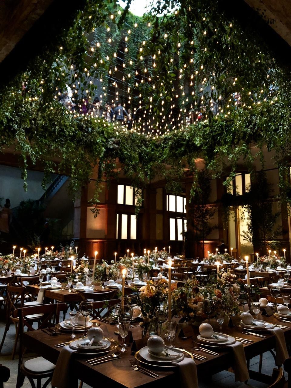 Salón montado por Marega con mesas de madera, velas y luces colgantes
